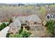 Stunning aerial view of the brick estate with its sprawling layout, elegant design, and meticulously landscaped grounds at 13142 Overlook Pass, Roswell, GA 30075