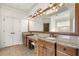 Bathroom featuring double sinks with granite counters, framed mirror, wood cabinets, and designer lighting at 13142 Overlook Pass, Roswell, GA 30075