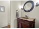 Elegant powder room featuring a carved wood vanity, marble countertop, and decorative oval mirror at 13142 Overlook Pass, Roswell, GA 30075
