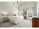 Bright bedroom features a large bed, soft carpet, and large windows overlooking a serene setting at 13142 Overlook Pass, Roswell, GA 30075