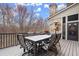 Outdoor deck with a dining table, barbecue grill, and scenic backyard views at 13142 Overlook Pass, Roswell, GA 30075