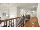 Elegant hallway featuring wood floors, staircase, and a stylish light fixture at 13142 Overlook Pass, Roswell, GA 30075