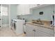Bright laundry room with granite counters, sink, and modern washer and dryer units at 13142 Overlook Pass, Roswell, GA 30075