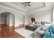 Open-concept living room with hardwood floors, tray ceilings, and an arched entryway at 13142 Overlook Pass, Roswell, GA 30075