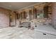 Covered patio with stone flooring, brick walls, and stylish outdoor seating at 13142 Overlook Pass, Roswell, GA 30075