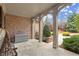 Covered porch with stone flooring, brick pillars, and view of landscaped backyard at 13142 Overlook Pass, Roswell, GA 30075