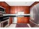 Modern kitchen boasts stainless appliances, dark granite countertops, and cherry cabinets at 195 14Th Ne St # Ph 306, Atlanta, GA 30309