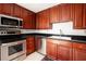 Well-lit kitchen with stainless steel appliances, dark countertops and wood cabinets at 195 14Th Ne St # Ph 306, Atlanta, GA 30309