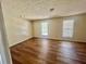 Bedroom with hardwood floors, two windows, and neutral paint, bathed in soft natural light at 2695 Lindsey Oak Ln, Lawrenceville, GA 30044