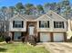 Split level home with a brick and siding exterior, a two-car garage, and mature trees at 2695 Lindsey Oak Ln, Lawrenceville, GA 30044