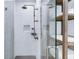 Modern shower featuring a glass door, white tile, updated shower head, and shelving at 45 Ivan Allen Jr Nw Blvd # 1704, Atlanta, GA 30308