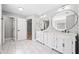 Bright bathroom featuring double vanity, round mirrors, white cabinets, and tiled floors at 50 Riverstone Dr, Covington, GA 30014