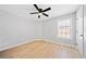 Inviting bedroom with a modern ceiling fan, bright window, and stylish hardwood floors at 50 Riverstone Dr, Covington, GA 30014