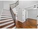 Elegant foyer showcases hardwood floors, staircase with iron spindles, and access to multiple rooms at 50 Riverstone Dr, Covington, GA 30014