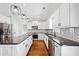 Modern kitchen boasts white cabinets, black countertops, subway tile backsplash, and stainless appliances at 50 Riverstone Dr, Covington, GA 30014