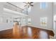 Open-concept living room features hardwood floors, large windows, a view of the kitchen, and a fireplace at 50 Riverstone Dr, Covington, GA 30014