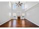 Bright living room featuring soaring ceilings, a decorative fireplace, a ceiling fan, and hardwood floors at 50 Riverstone Dr, Covington, GA 30014