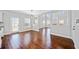 Bright open-concept living area boasts gleaming hardwood floors and ample natural light from windows and glass door at 50 Riverstone Dr, Covington, GA 30014