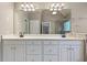 Bathroom with a large mirror, dual sinks, white vanity, and lots of storage in the cabinets beneath the sink at 711 Wilhaven Ct, Loganville, GA 30052