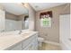 Bathroom with a single sink vanity, a window, a mirror, and a toilet at 711 Wilhaven Ct, Loganville, GA 30052