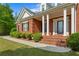 Close up on the front porch, showing red brick steps and white columns at 711 Wilhaven Ct, Loganville, GA 30052