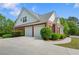 Exterior of the two car garage, featuring a paved drive and manicured shrubbery at 711 Wilhaven Ct, Loganville, GA 30052