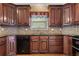 This kitchen features tile backsplash, wooden cabinets, and a black dishwasher at 711 Wilhaven Ct, Loganville, GA 30052