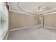 Bright, spacious main bedroom with a tray ceiling, fan, neutral color palette, and large window, great for natural light at 711 Wilhaven Ct, Loganville, GA 30052