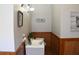 Elegant half-bath featuring decorative wood paneling, stylish fixtures, and unique artwork at 885 White Sw St, Atlanta, GA 30310