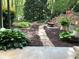 A tranquil backyard featuring a stone walkway, lush greenery, and a cozy fire pit at 5395 Steeple Chase, Douglasville, GA 30135