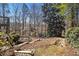 Landscaped backyard featuring natural elements and wooden deck supports, creating a serene outdoor environment at 5395 Steeple Chase, Douglasville, GA 30135