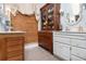 Charming bathroom with dual vanities, tile flooring, and antique cabinet for storage at 5395 Steeple Chase, Douglasville, GA 30135