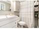 Cozy bathroom with white vanity, toilet, shower with curtain, and open shelves for towels and plants at 5395 Steeple Chase, Douglasville, GA 30135