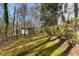 Secluded backyard featuring a lush lawn, mature trees, and a charming storage shed at 740 Frank Kirk Nw Rd, Kennesaw, GA 30152