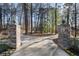 Stone pillars and wrought iron gate marking the entrance to the tree-lined property at 740 Frank Kirk Nw Rd, Kennesaw, GA 30152