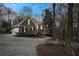 Gray home with attached garage amid a wooded landscape, illuminated by outdoor lighting at 740 Frank Kirk Nw Rd, Kennesaw, GA 30152