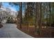 Gray home with attached garage amid a wooded landscape, illuminated by outdoor lighting at 740 Frank Kirk Nw Rd, Kennesaw, GA 30152