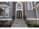 Stone staircase leads up to an ornate black double door framed by elegant windows and stone accents at 740 Frank Kirk Nw Rd, Kennesaw, GA 30152