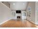 Bright living room featuring vaulted ceiling, fireplace with built-ins, and arch window with nature view at 740 Frank Kirk Nw Rd, Kennesaw, GA 30152