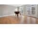 Sun-filled living room features hardwood floors, a piano, and double doors leading to the outdoor space at 740 Frank Kirk Nw Rd, Kennesaw, GA 30152