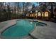 Backyard with a large in-ground pool and hot tub, surrounded by a deck, black fence, and lush greenery at 740 Frank Kirk Nw Rd, Kennesaw, GA 30152