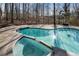 Close up on sparkling pool and spa combo surrounded by a concrete deck and mature trees at 740 Frank Kirk Nw Rd, Kennesaw, GA 30152