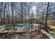 Backyard pool with iron fence and wooded views provides a private oasis for relaxation and recreation at 740 Frank Kirk Nw Rd, Kennesaw, GA 30152