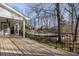 Spacious porch with a wood deck and black railing, offering views of the swimming pool and wooded backyard at 740 Frank Kirk Nw Rd, Kennesaw, GA 30152