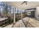 Inviting covered porch featuring a stained wood deck, classic columns, and views of the surrounding wooded landscape at 740 Frank Kirk Nw Rd, Kennesaw, GA 30152