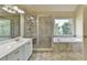 Light and bright bathroom features double vanity, glass shower and soaking tub at 106 Little Barley Ln, Grayson, GA 30017