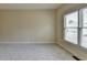 Bedroom with neutral carpet and paint, a large window, and base trim molding at 106 Little Barley Ln, Grayson, GA 30017