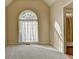 A neutral bedroom is accented by a large arched window with sheer curtains, filling the room with light at 106 Little Barley Ln, Grayson, GA 30017