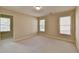 A bedroom with neutral walls, soft carpet, natural light from windows, and an open doorway at 106 Little Barley Ln, Grayson, GA 30017