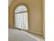 A neutral bedroom is accented by a large arched window with sheer curtains, filling the room with light at 106 Little Barley Ln, Grayson, GA 30017